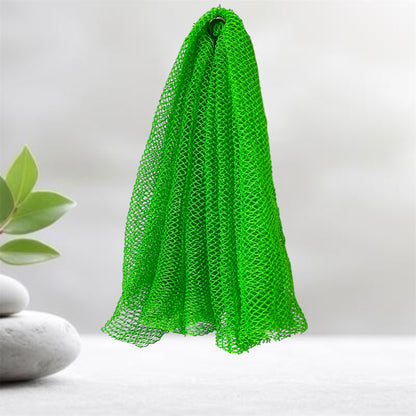 Green mesh scrubber hanging on a hook with a plant and stones in the background